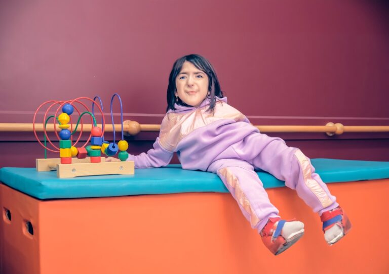 A parent and child sit together in a cozy living room, surrounded by soft lighting and sensory toys.